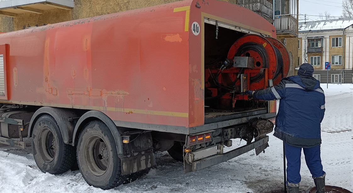 Каналопромывочная машина и работник прочищают засор в канализационной системе в Липецке