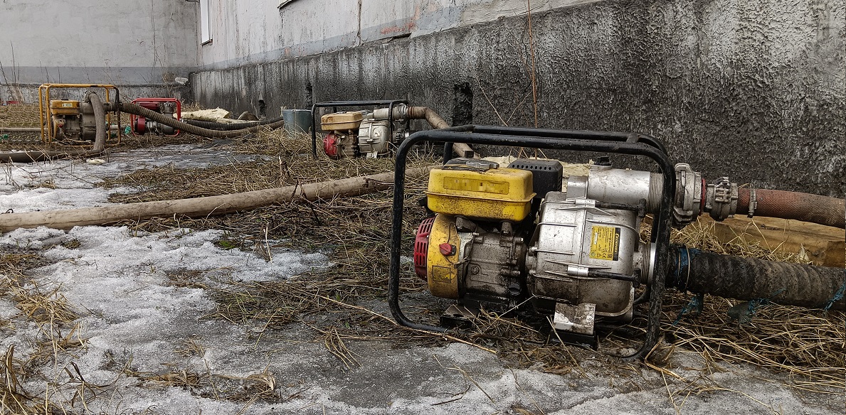 Откачка мотопомпами талой воды из подвала дома в Задонске